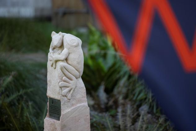 Animal research memorial stone statue with a glimpse of UOW banner