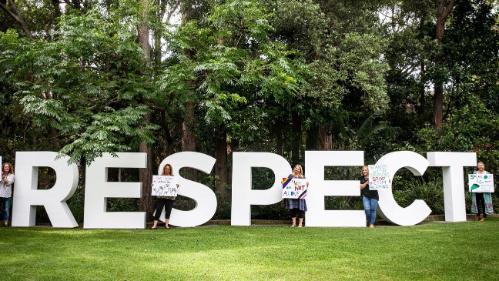 Respect week girls in front of big RESPECT letters