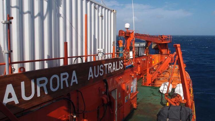 The name of teh ship Aurora Australis is written in white against the bright red of the vessel.