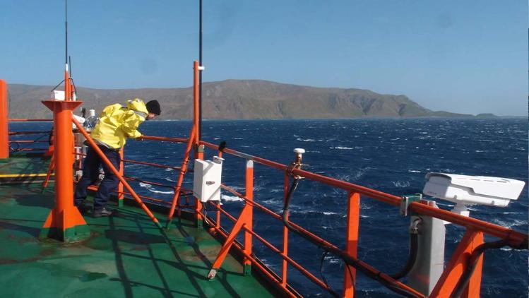 Aurora Australis crew mate peers over the side of the vessel as it heads toward shore