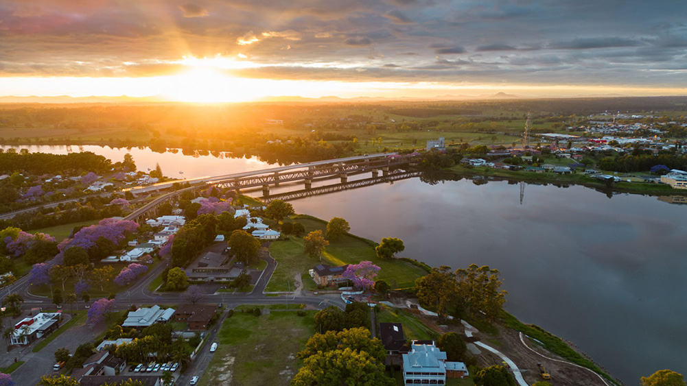 Ariel view of Grafton town and river at sunset. Sun peaking through the clouds.