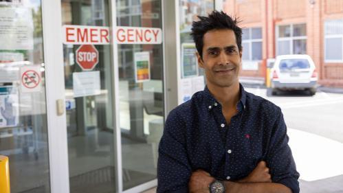 Man standing outside emergency room entrance