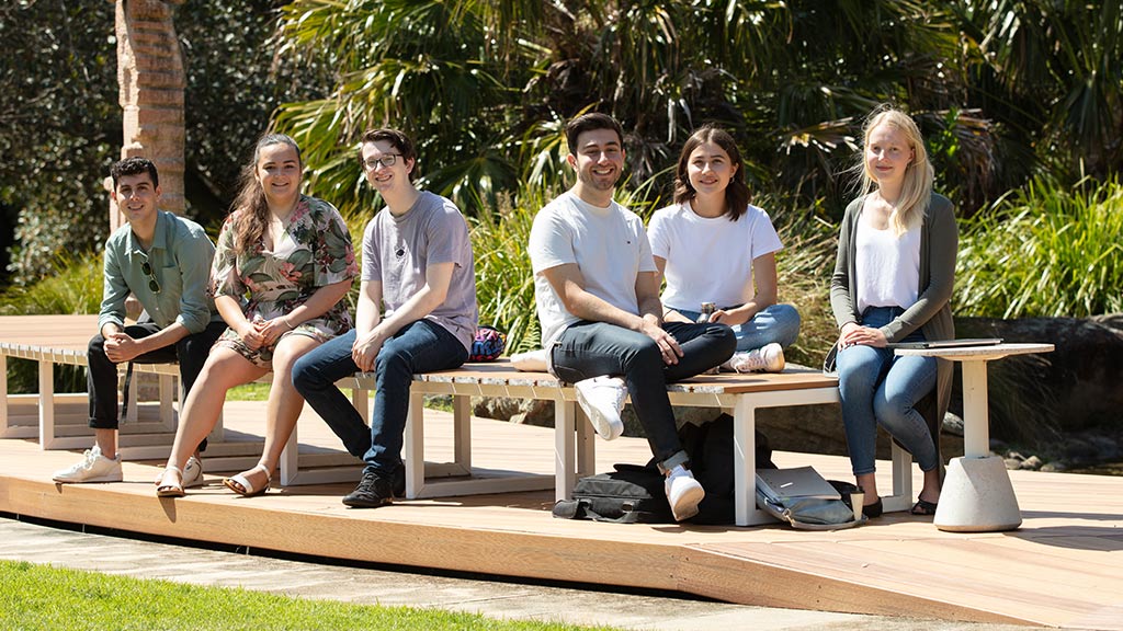 Liberal Arts students sit on a bench on the McKinnon Lawn