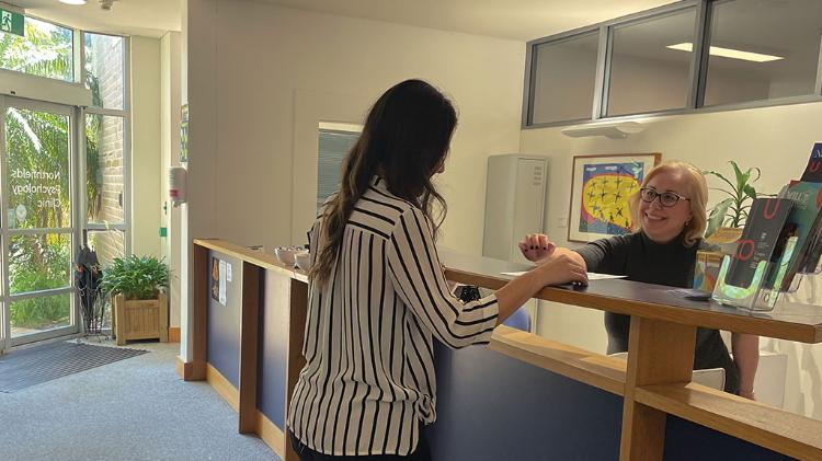 Northfields Clinic Receptionist explaining referral form to client