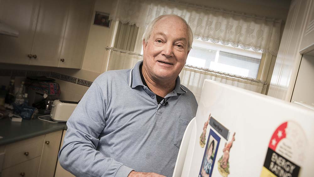 Peter, stands at his fridge with the door open