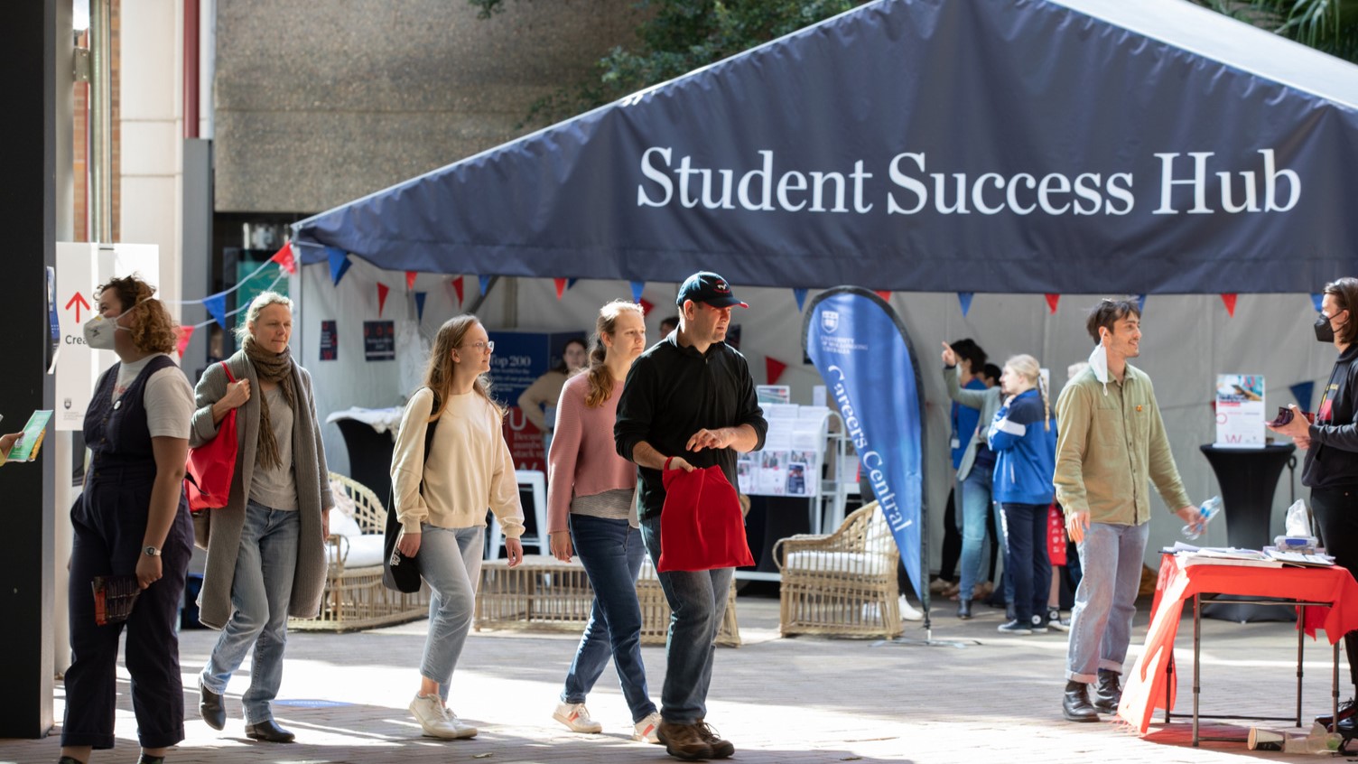 Students on walking campus with the Student Success Hub information tent in the background