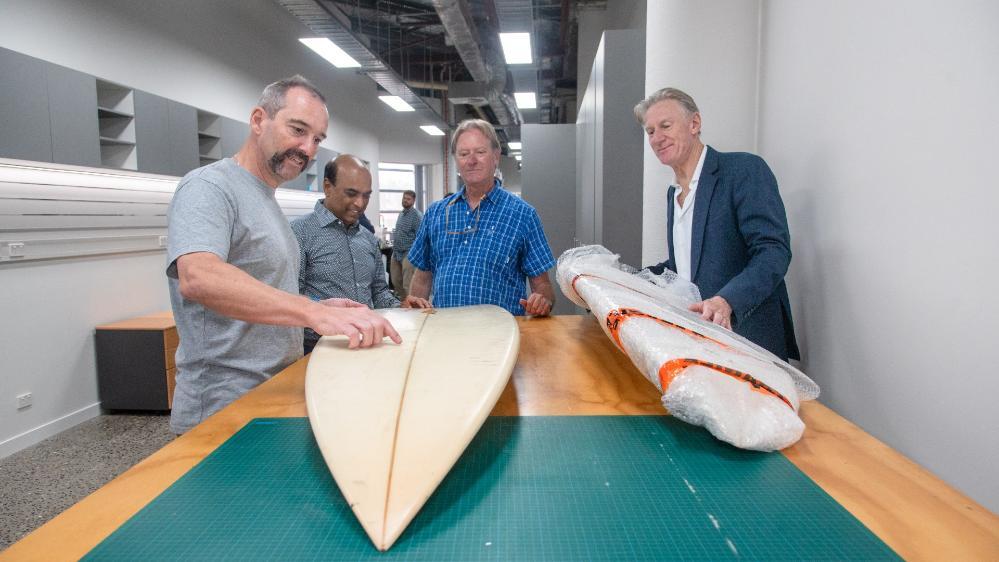 Marc in het Panhuis examines a surfboard with fellow researchers on the project. Photo: Supplied