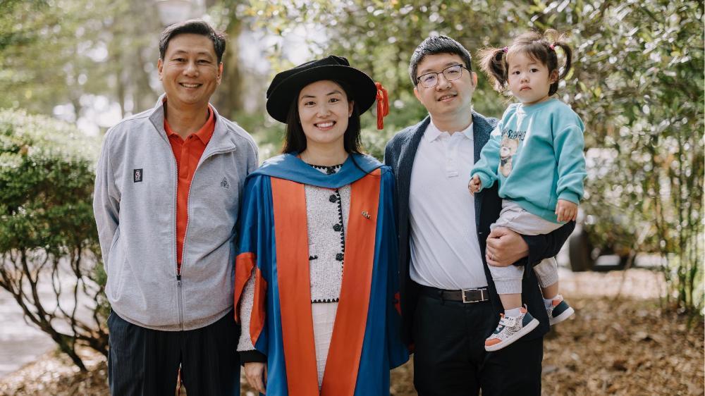 Dr Susan Zhang with her husband, young daughter and father at the Faculty of Engineering and Information Sciences graduation ceremony, October 2024.