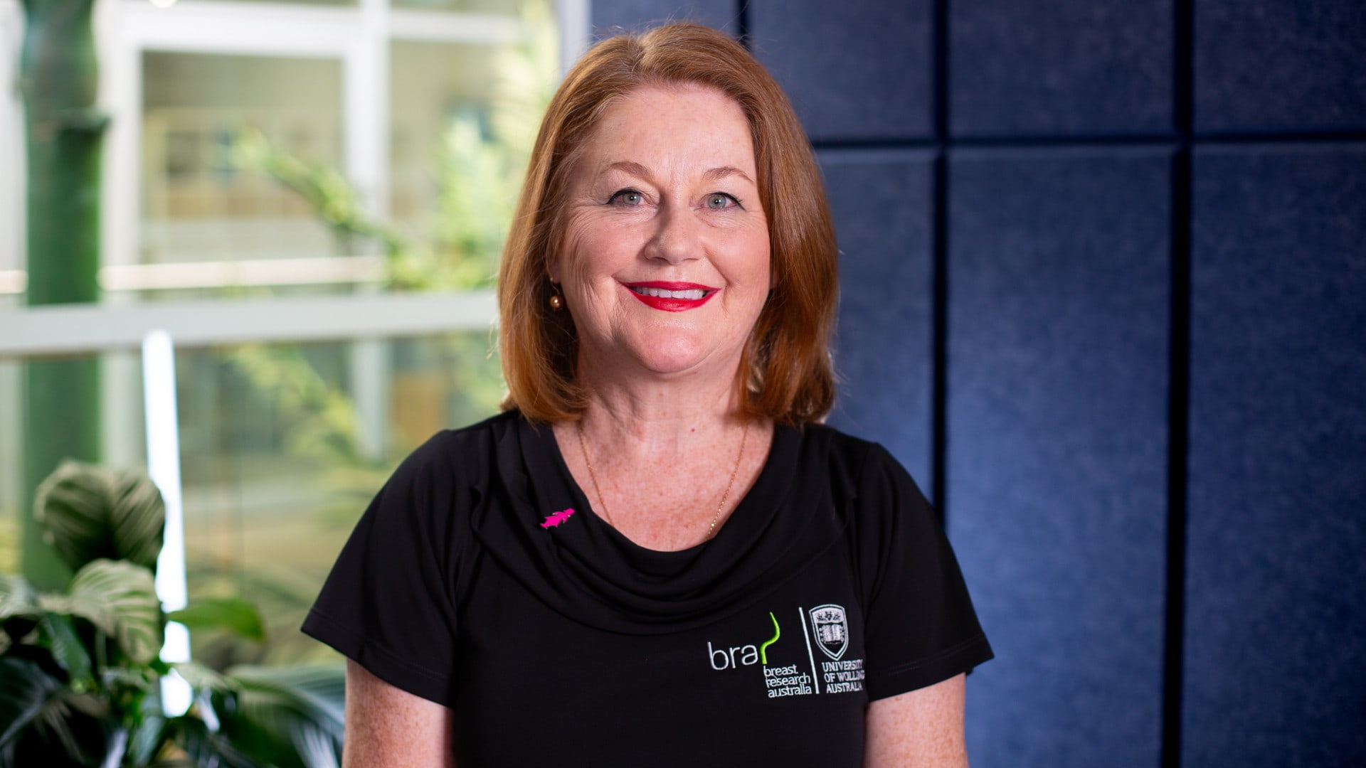 A women wears a black t-shirt, with Breast Research Australia as the emblem, and smiles. Photo: Supplied