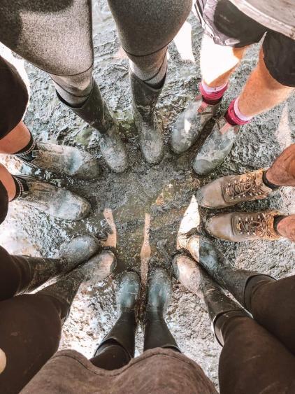The camera looks down on six pairs of muddy gumboots. Photo: Gabriella Marriott