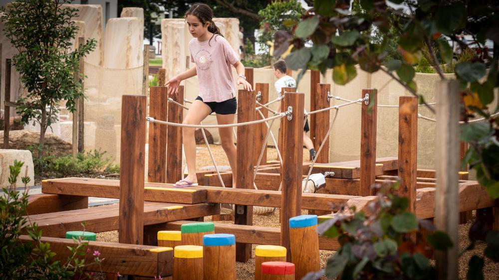 Children use the play equipment at the new All Ages All Abilities playground in Wollongong.