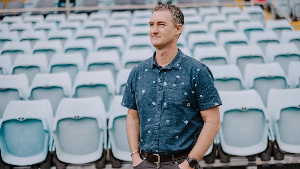 Dr Greg Peoples stands with the seats of WIN Stadium in the background. Photo: Michael Gray