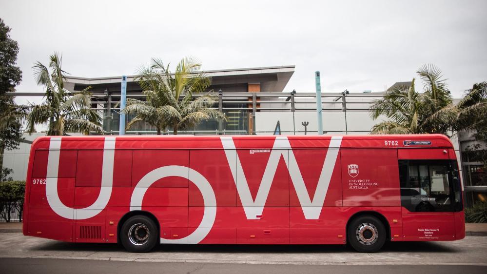 A red UOW electric bus is parked outside Early Start. Photo: Michael Gray