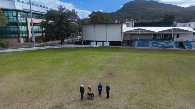 The team from Yours and Owls with UOW Vice-Chancellor Professor Patricia M Davidson stand on the oval at UOW. The image looks across the Mount Keira. Photo: Mark Newsham