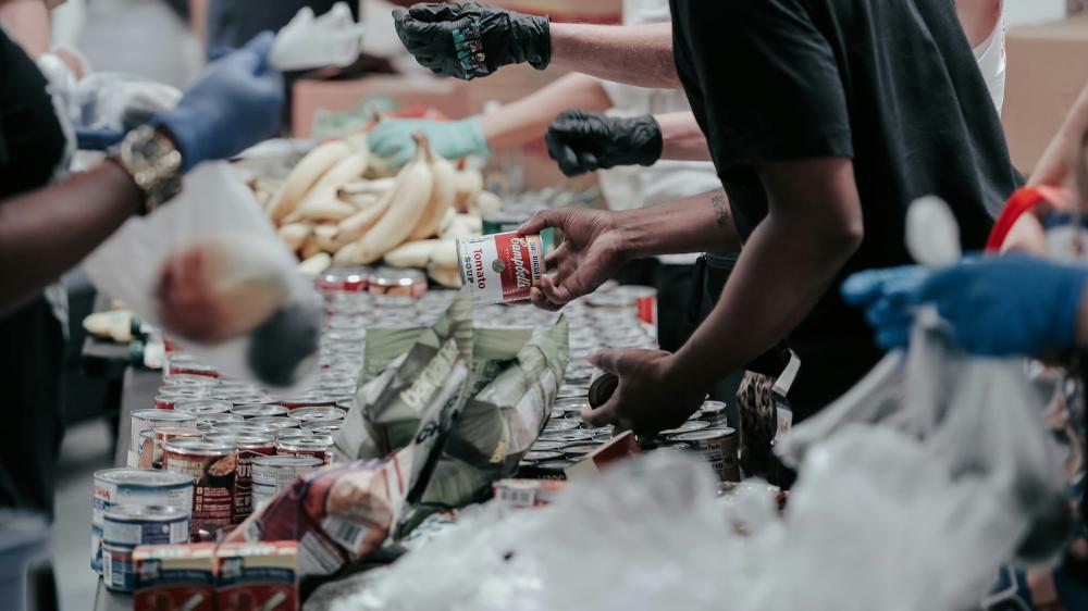 Volunteers pack bags of cans and produce at a food bank. Photo: Unsplash